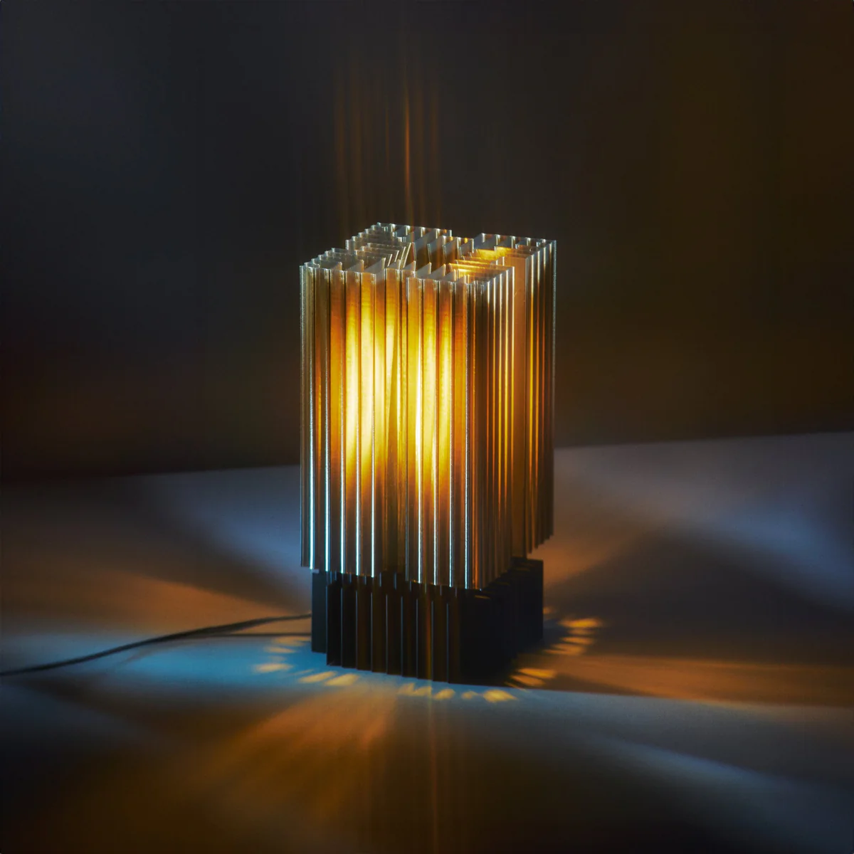 Modern cylindrical lamp with ribbed design on a dark background